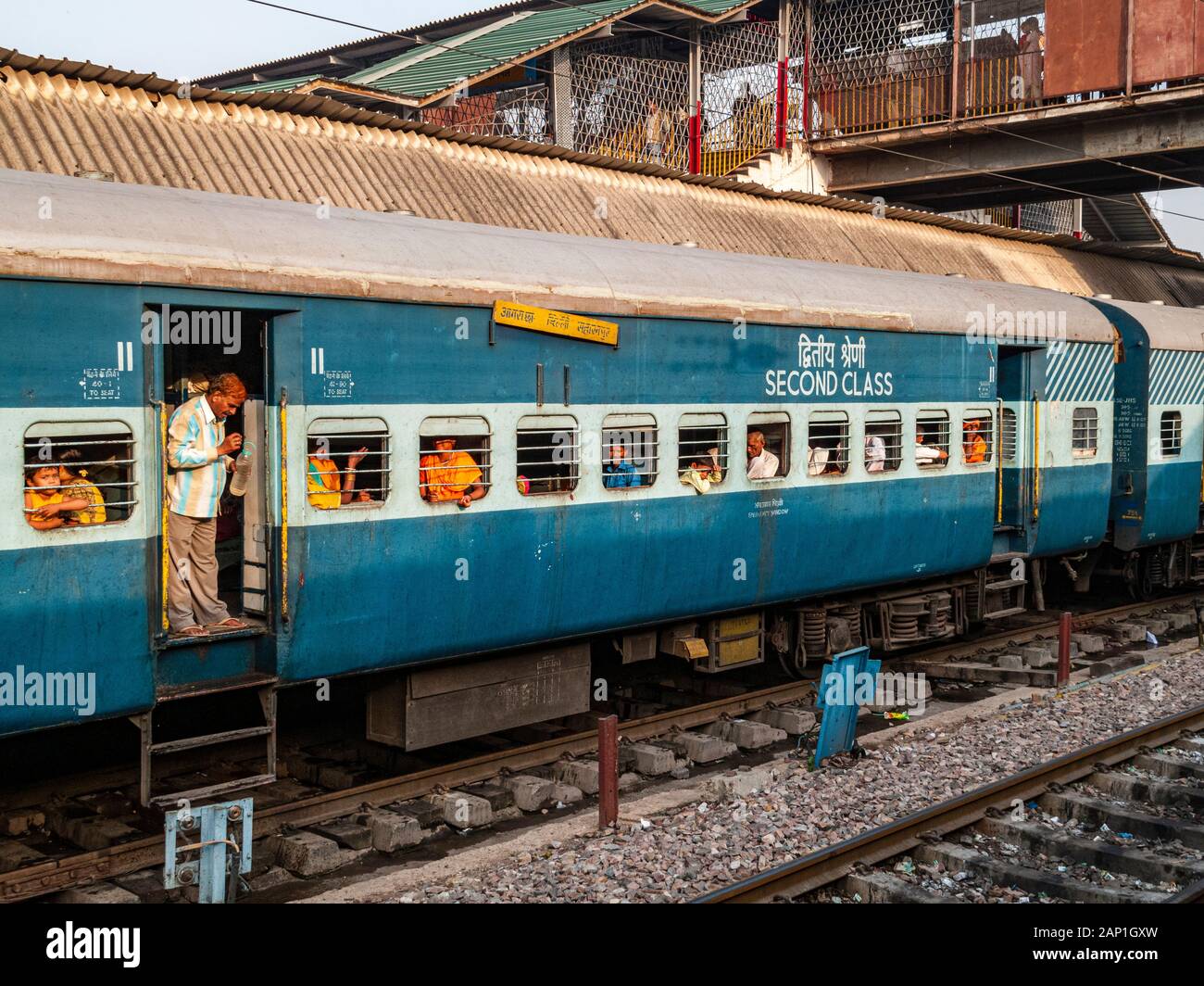 Bars für die Sicherheit vor den Fenstern eines indischen Eisenbahn-Busses blicken die Passagiere aus Stockfoto