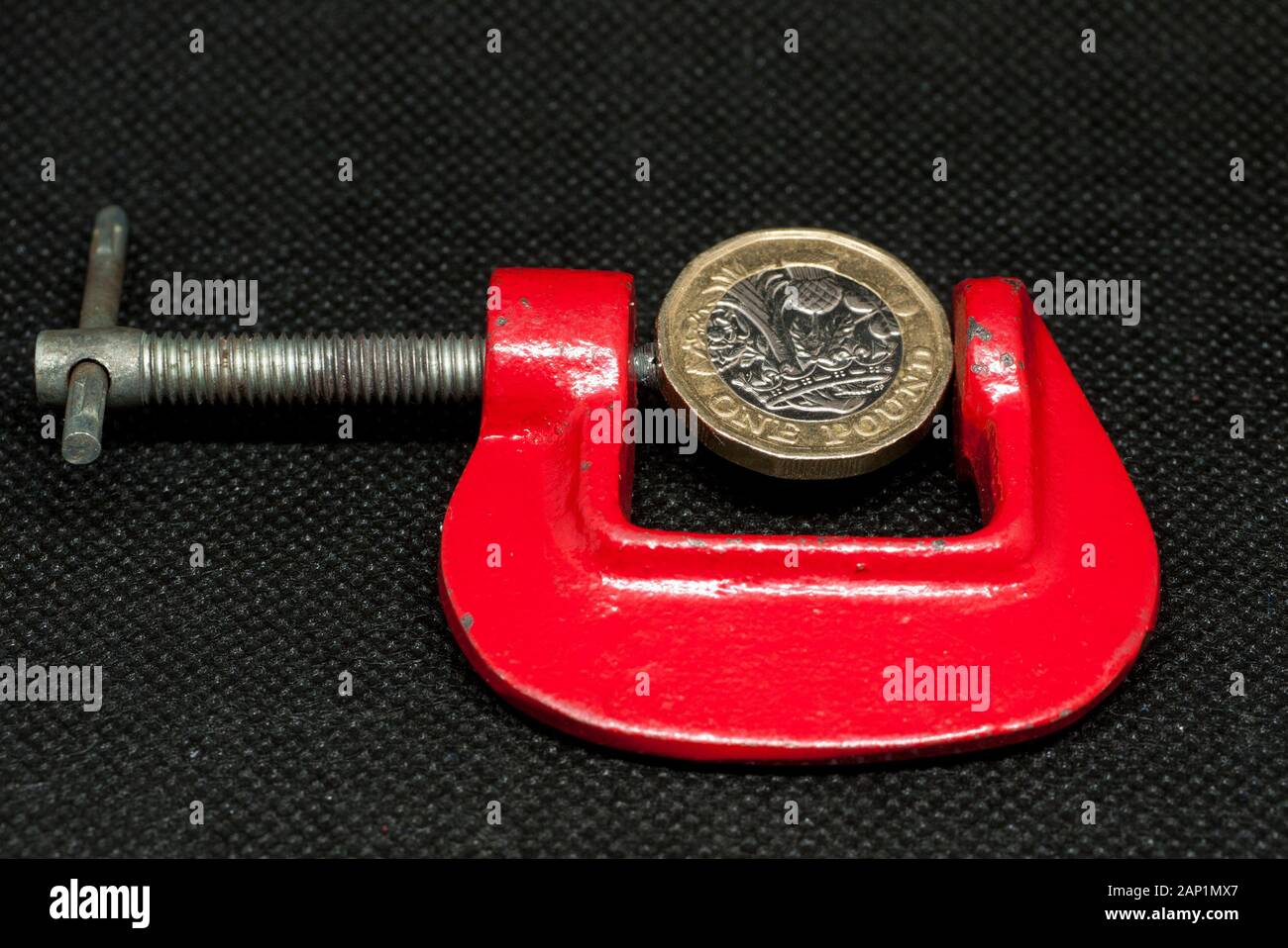 Eine britische Pfund Münze in einer C-Klemme, Großbritannien. Stockfoto