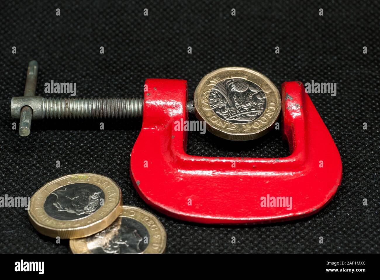 Eine britische Pfund Münze in einer C-Klemme, Großbritannien. Stockfoto