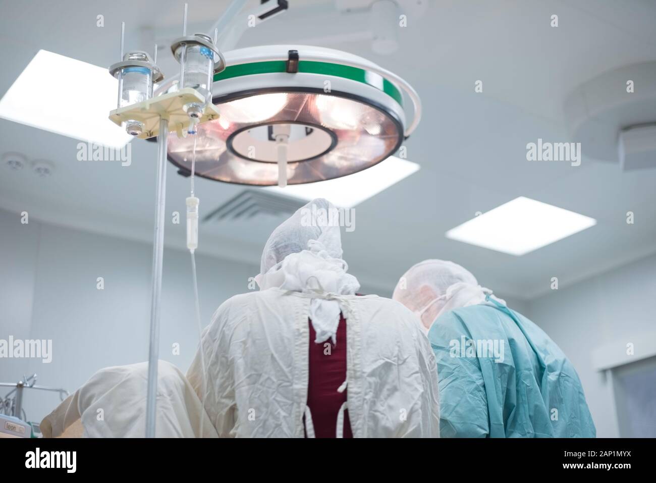 Niedrigen Winkel, Pädiatrie, Chirurgie, Chirurgen durchführen, die in einem sterilen Op. Der Blick von der Rückseite. Leuchtet das Feld Lampe. Ärzte profe Stockfoto