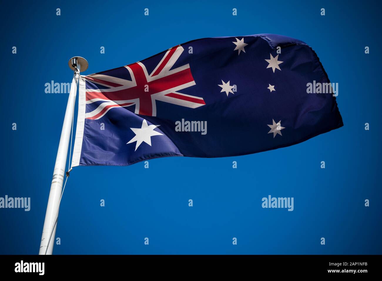 Australische Flagge im Wind fliegen gegen den klaren blauen Himmel Stockfoto