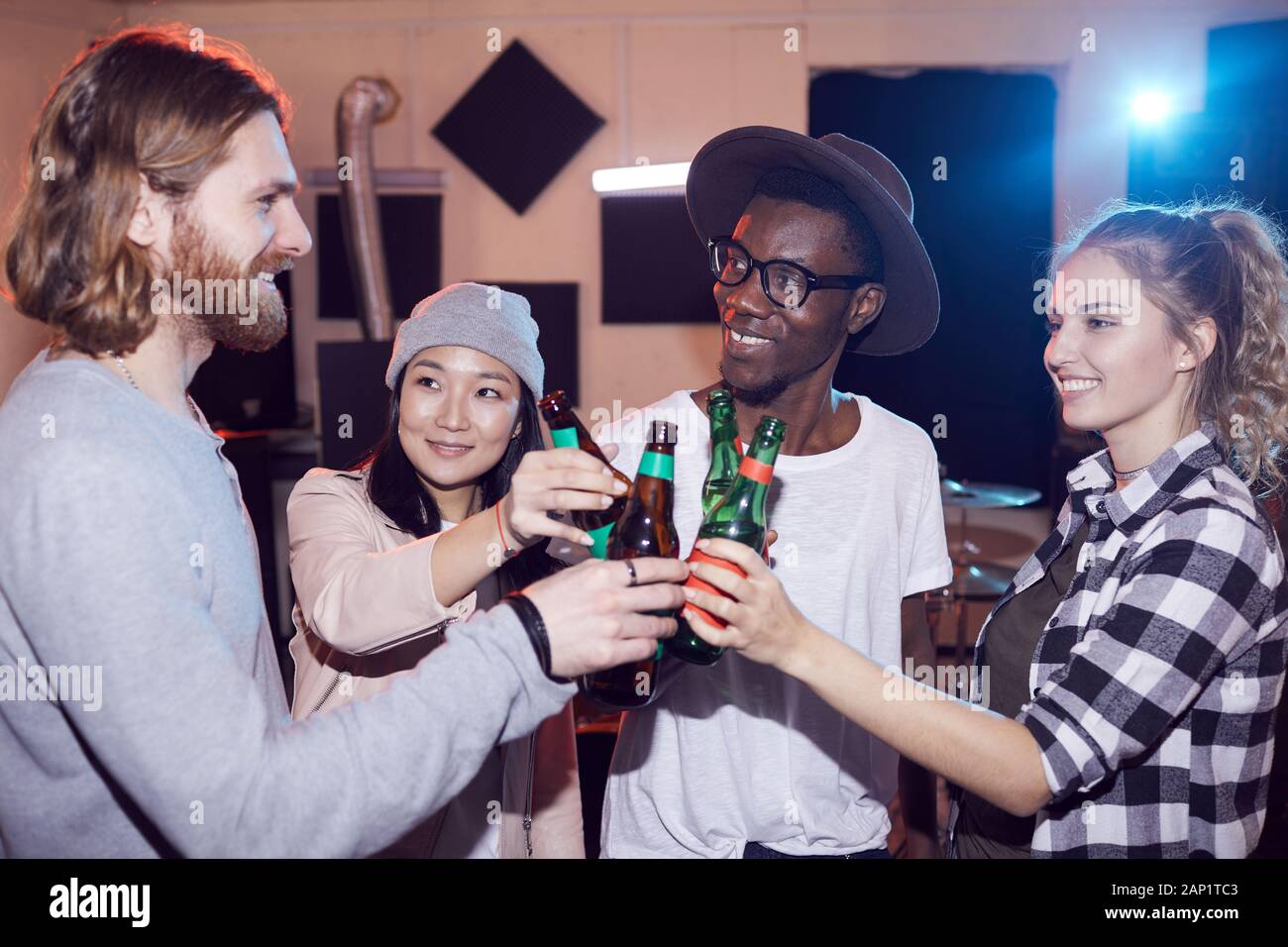 Multi-ethnischen Gruppe junger Leute Bier trinken und plaudern, während Sie Probe im Music Studio, Schuß mit Flash Stockfoto