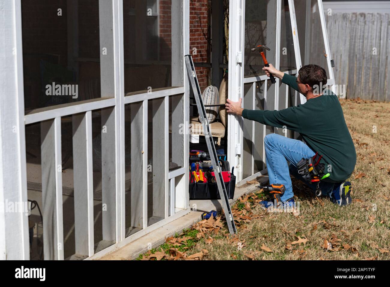 Man verwendet die hammer Tür auf der hinteren Veranda zu reparieren. Stockfoto