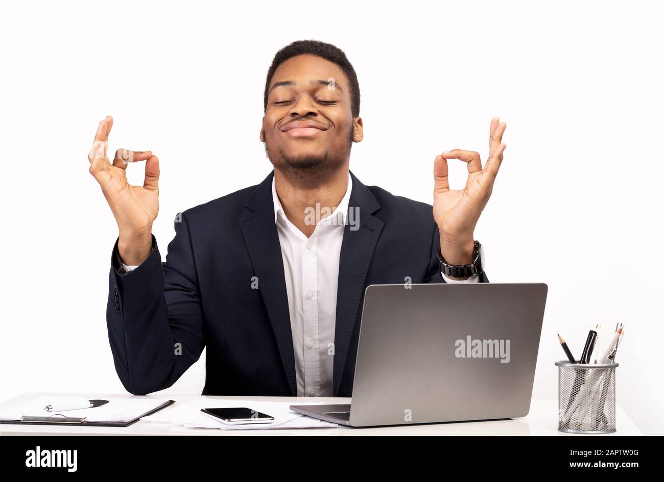 Ruhige schwarze Kerl meditieren während der Arbeit am PC Stockfoto
