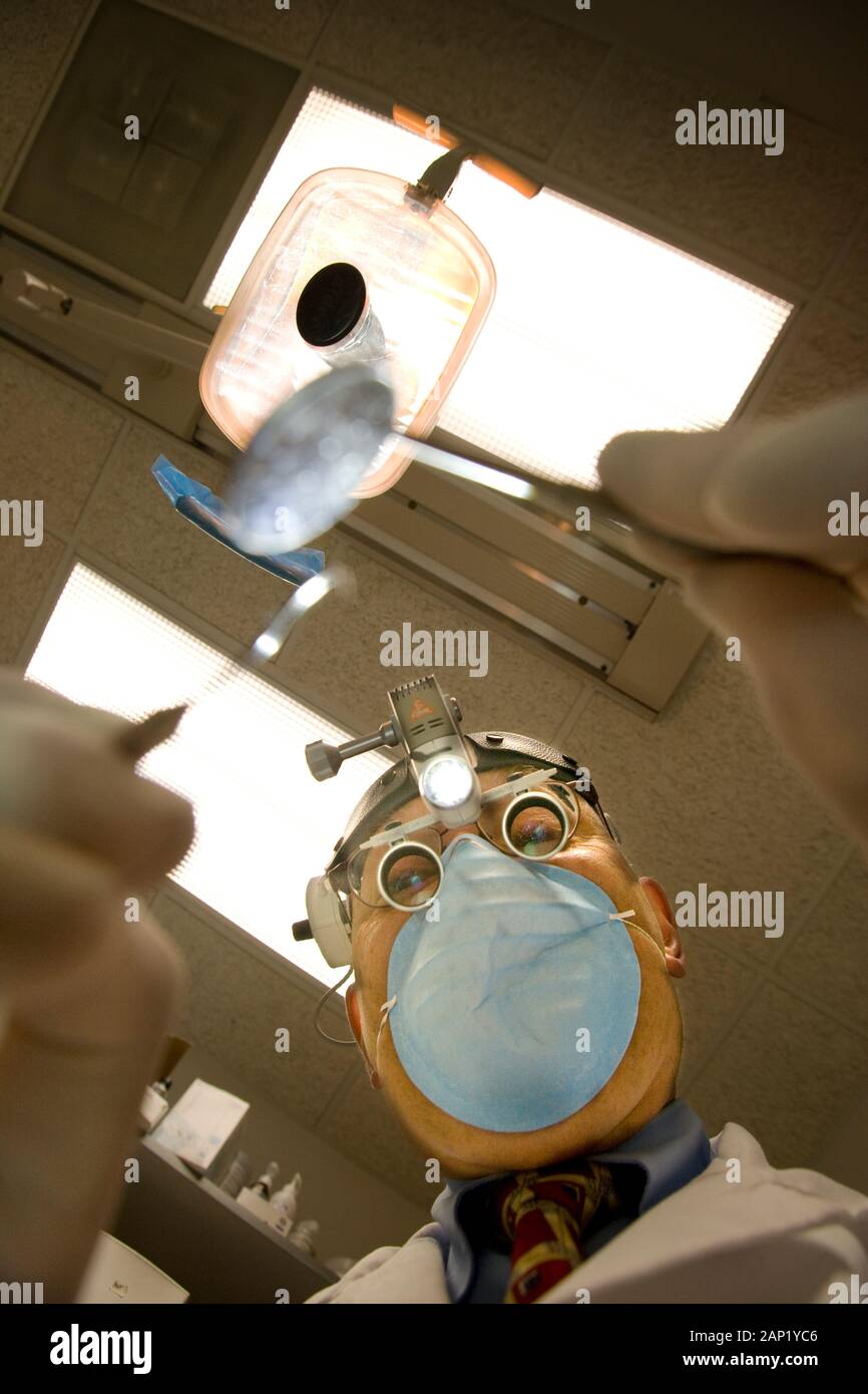 Beängstigendes, entnervtes, unheimlich Lustiges Zahnarztbild eines Zahnarztes, der den Mund eines Patienten probiert Stockfoto