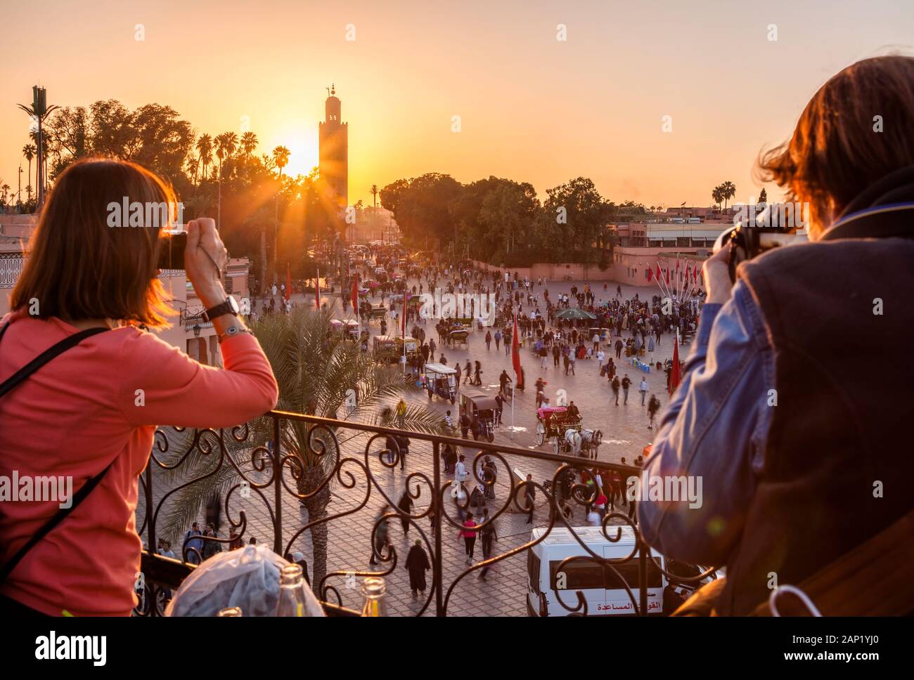 Touristen fotografieren Jemaa el-Fnaa bei Sonnenuntergang von der Terrasse Marrakesh-Safi in Marrakesch, Marokko. Stockfoto
