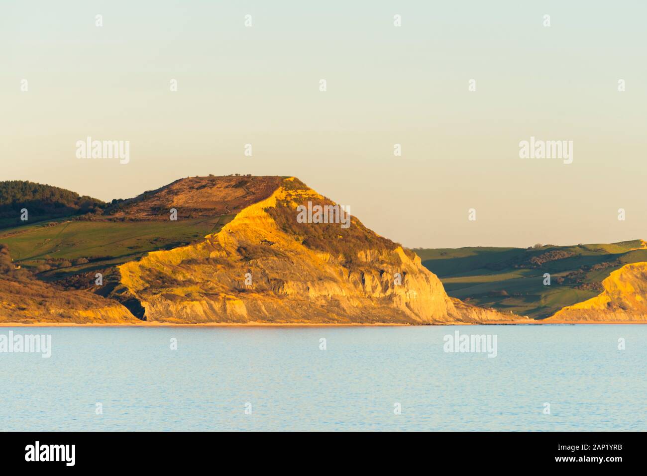 Lyme Regis, Dorset, Großbritannien. 20. Januar 2020. UK Wetter. Die Jurassic Coast Steilküste von Golden Cap glow Orange am späten Nachmittag Sonnenschein kurz vor Sonnenuntergang von Lyme Regis in Dorset am Ende eines kalten sonnigen Tag gesehen. Foto: Graham Jagd-/Alamy leben Nachrichten Stockfoto