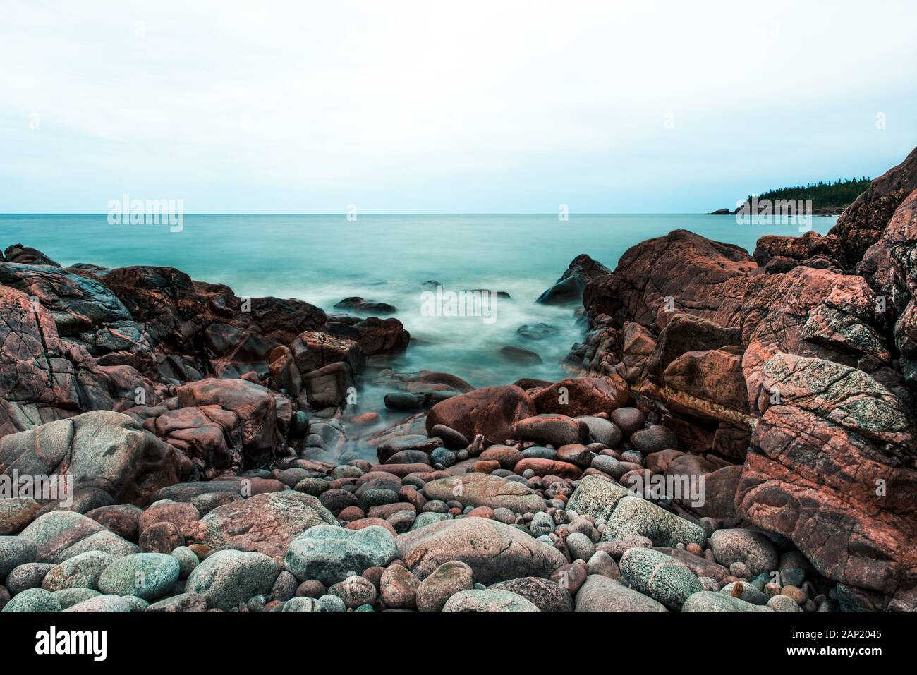 Rote Steine und felsige Küste am Black Brook Beach, Cape Breton Highlands National Park, Nova Scotia, Kanada. Landschaftlich reizvolle Naturlandschaft Stockfoto