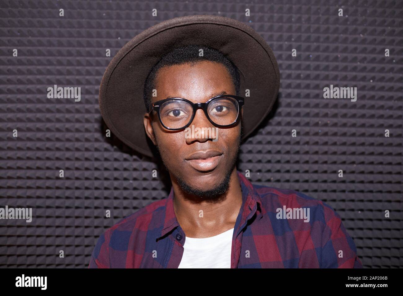 Kopf und Schultern Portrait von trendigen afrikanischen Mann an der Kamera, während im Nachtclub posiert, geschossen mit Flash Stockfoto