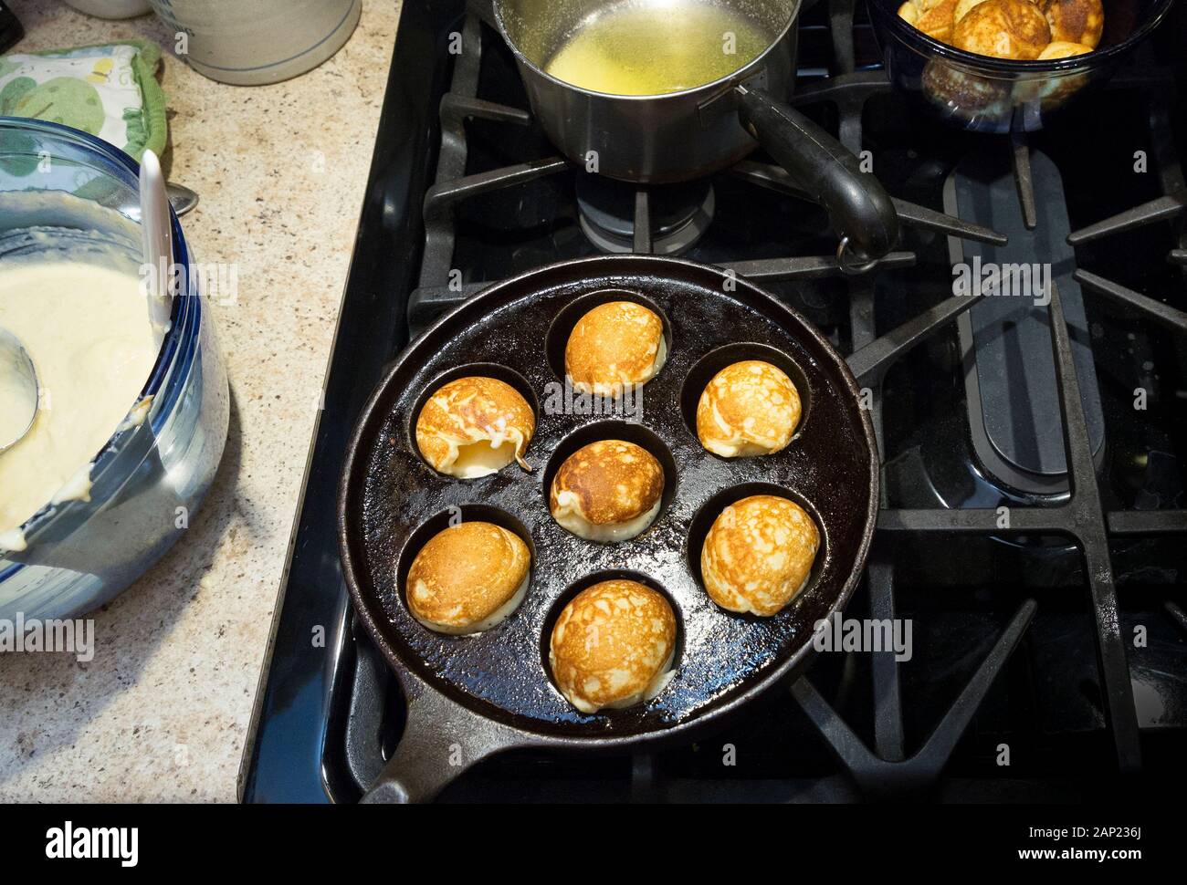 Eine gusseiserne Pfanne Kochen mit Teig für Aebleskiver, Dänisch runde Puff  Bälle oder Pfannkuchen gefüllt - das Rezept mit Weizenmehl, Buttermilch  Stockfotografie - Alamy