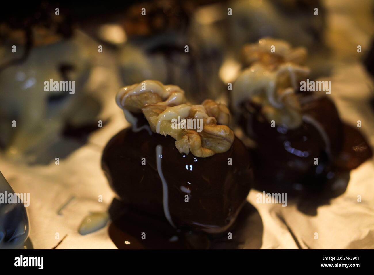 Makro Nahaufnahme der vielen isolierten frische hausgemachte weißer und brauner Schokolade Pralinen mit Termine Früchte, gefüllt mit Walnüssen dekoriert und Ausbreiten von Stockfoto