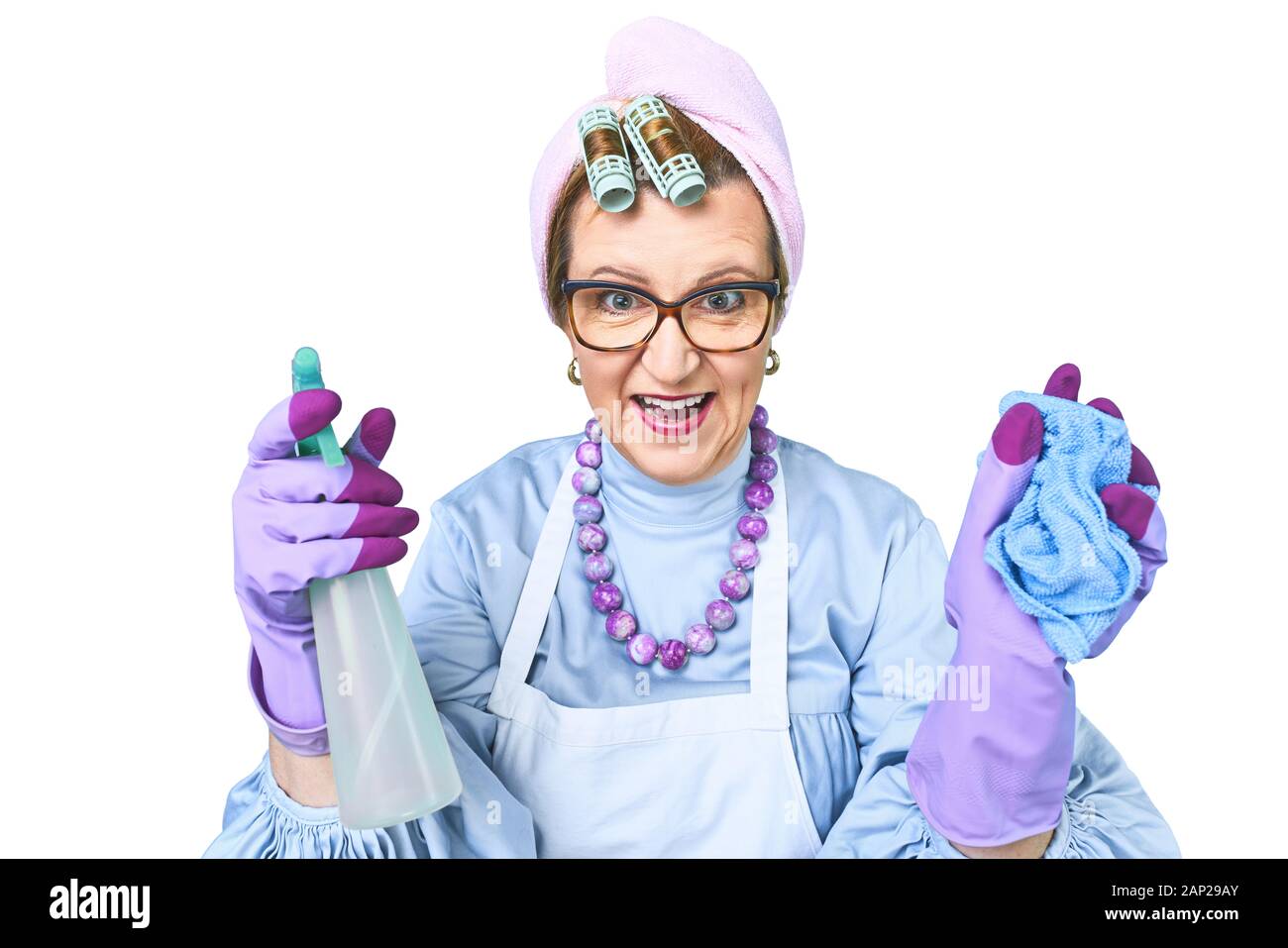Portrait der glücklichen alten Putzfrau in Schürze mit Staub Reinigungsbürste auf blauem Hintergrund isoliert. Spezielle einheitliche und professionelle Ausrüstung für Stockfoto