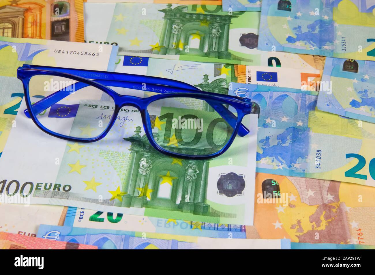 Viersen, Deutschland - Dezember 2. 2019: Ausgaben der jährlichen Kosten Konzept für neue Brillen bei Weitsichtigkeit oder Kurzsichtigkeit: Brillen auf Stapel von Euro pap Stockfoto