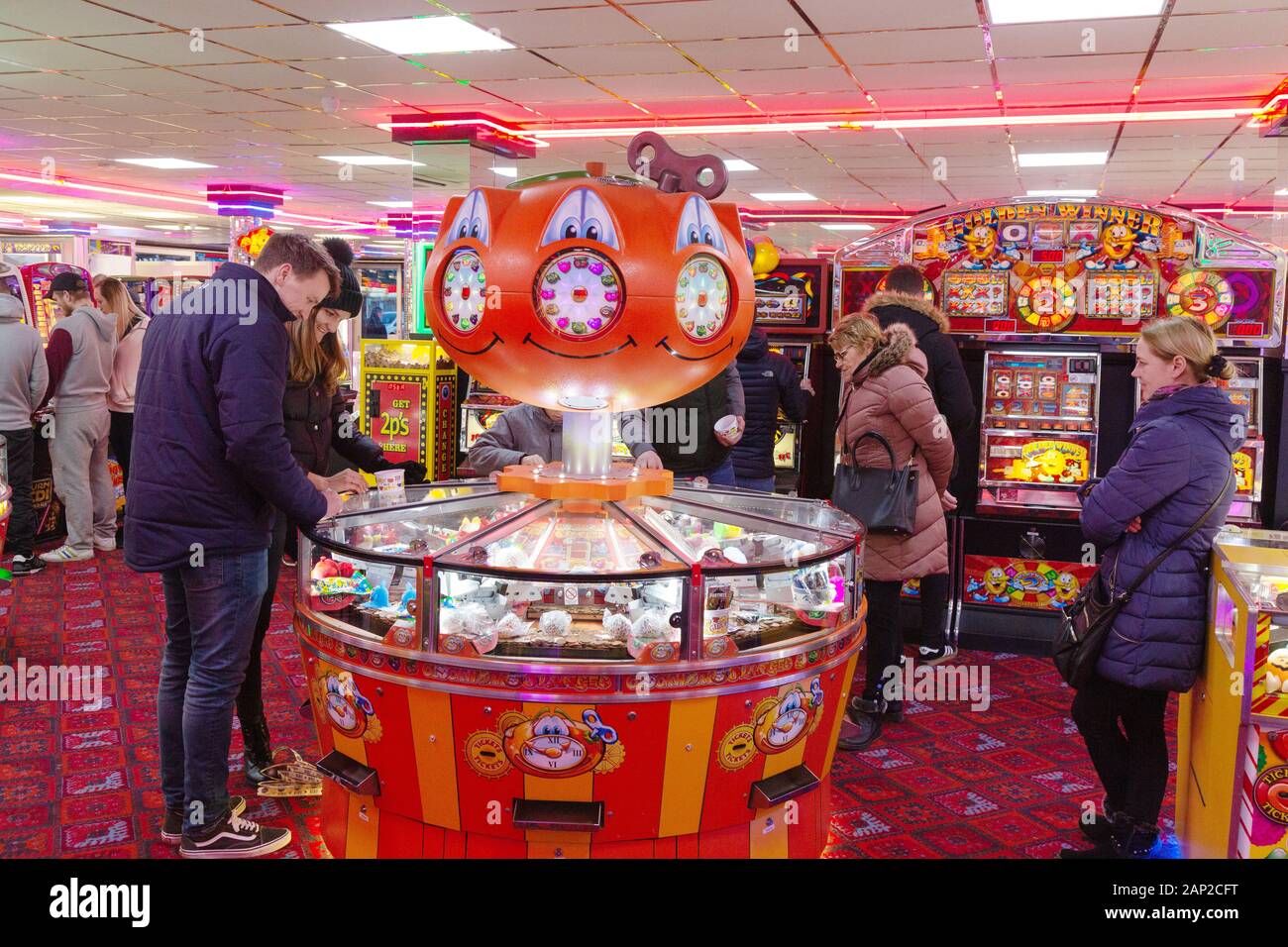 Spielhalle UK - Leute, die auf den Münzen oder Spielautomaten in der Vergnügungsparade Skegness Lincoln, UK, spielen Stockfoto