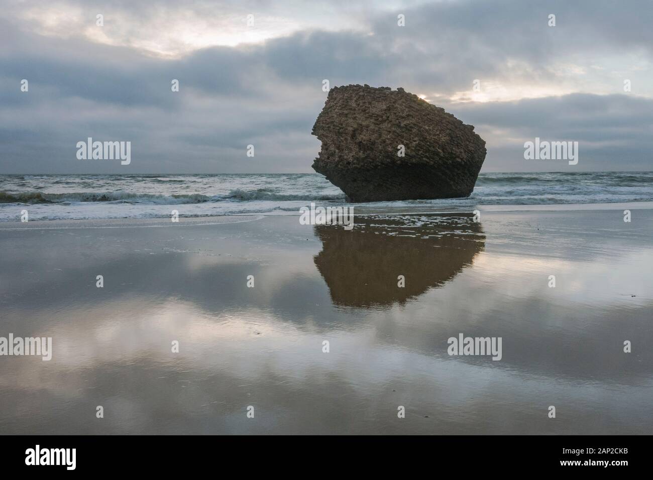 Der Felsen, Teil eines alten, auf dem Kopf stehenden Turms (Torre de la Higuera) am Strand in Matalascañas, Huelva, Spanien. Stockfoto