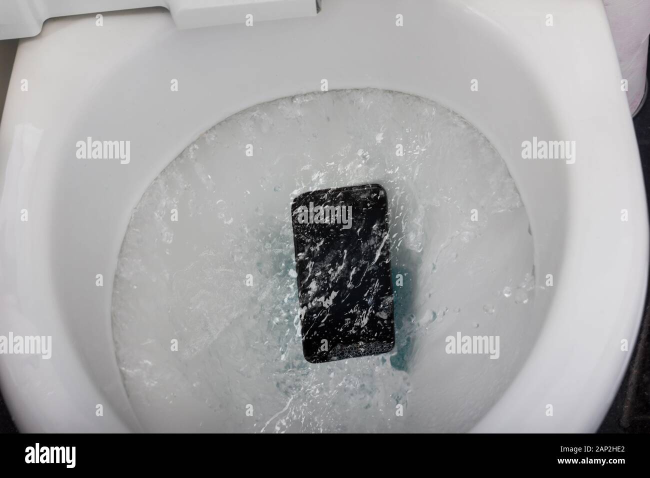 Schwarz Handy fallen in die Toilettenspülung Stockfoto