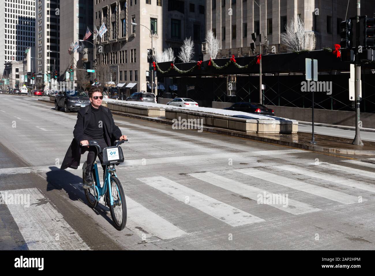 Chicago, USA - 30. Dezember 2018: Mann, einem blauen Kunststoffschlichte Leihfahrrad auf der Michigan Avenue. Bike Sharing ist eine beliebte Option in Chicago, mit über Stockfoto Chicago, USA - 30. Dezember 2018: Mann, einem blauen Kunststoffschlichte Leihfahrrad auf der Michigan Avenue. Bike Sharing ist eine beliebte Option in Chicago, mit über Stockfoto
