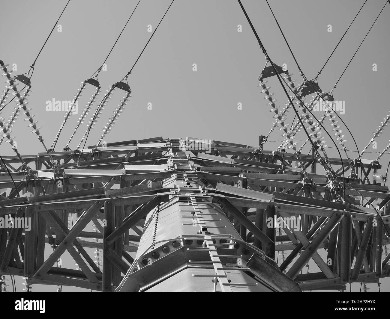 Große elektrische Pole mit Drähten gegen den blauen Himmel schwarz und weiß Foto Stockfoto