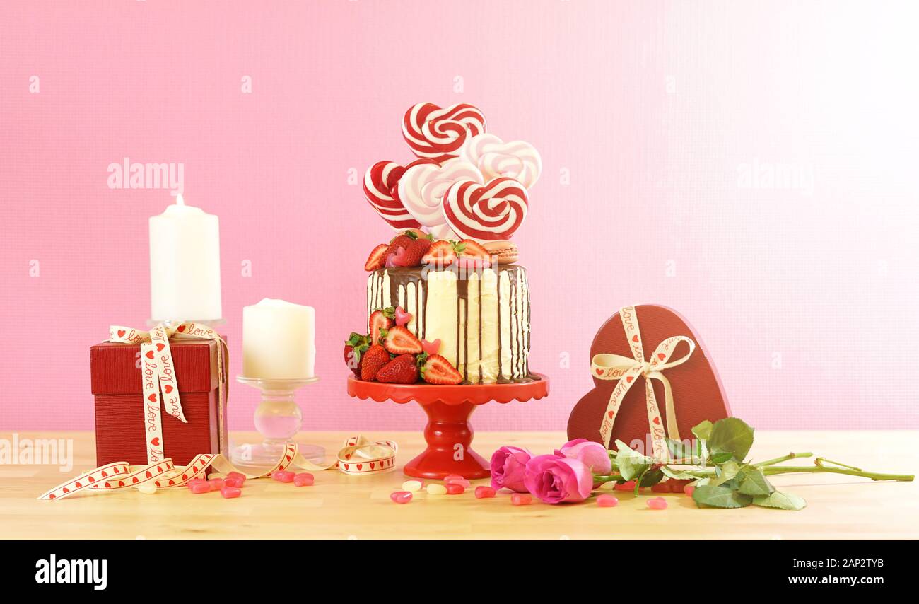 Valentinstag auf - Tendenz candyland Fantasy drip Neuheit Kuchen mit herzförmige Lollis, Candy und frische Erdbeeren dekoriert, mit Lens Flare ein Stockfoto