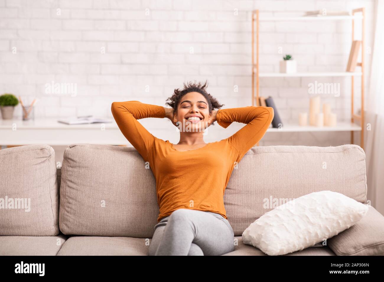 Gerne schwarze Frau Entspannen auf dem Sofa zu Hause sitzen Stockfoto