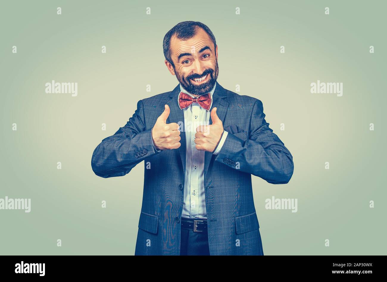 Gerne reife Mitte - bärtiger alter Mann lächelnd geben Daumen bis wie, gute Bewertung mit beiden Händen. Gemischte Rasse bearded Modell isoliert auf Green Yello Stockfoto