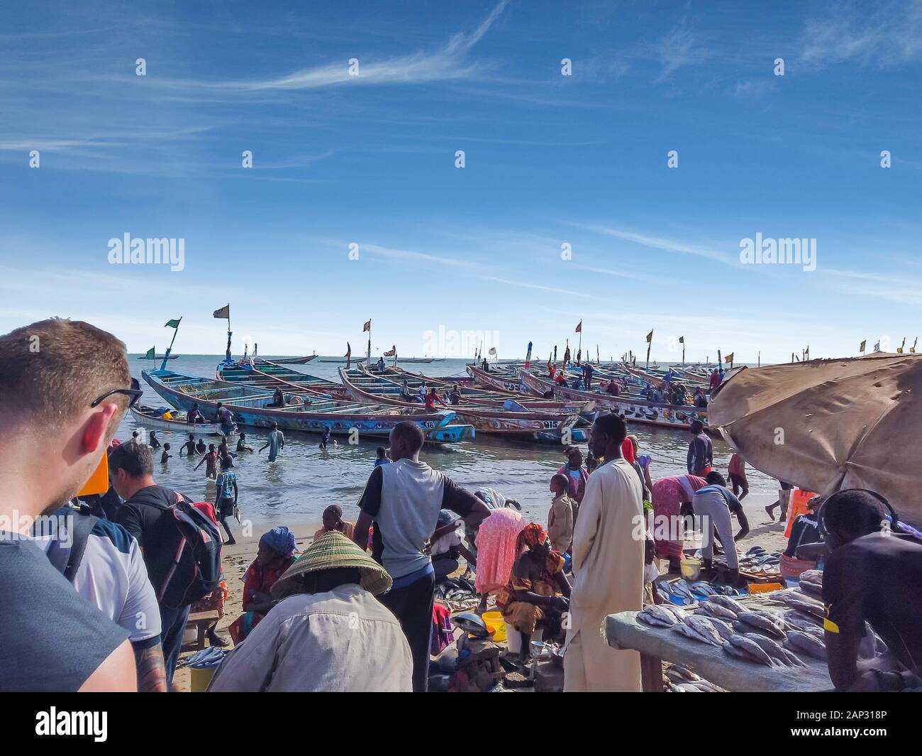 MBour, Senegal - 25. April 2019: Unbekannter senegalesischen Männer und Frauen auf dem Fischmarkt Im Hafen City in der Nähe von Dakar. Es gibt Verkaufsstände und Stockfoto