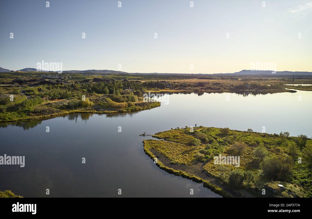Von oben erstaunliche Landschaft von gewundenen Fluss Küste mit grünen Büsche und Bäume gegen den Hügel am Horizont unter klaren Himmel Stockfoto