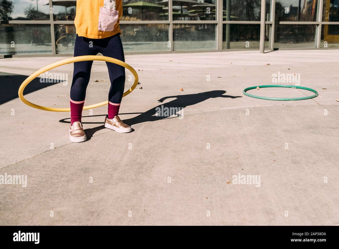 Hula Hula Hooping Mädchen auf einer Terrasse an einem Sommertag Stockfoto