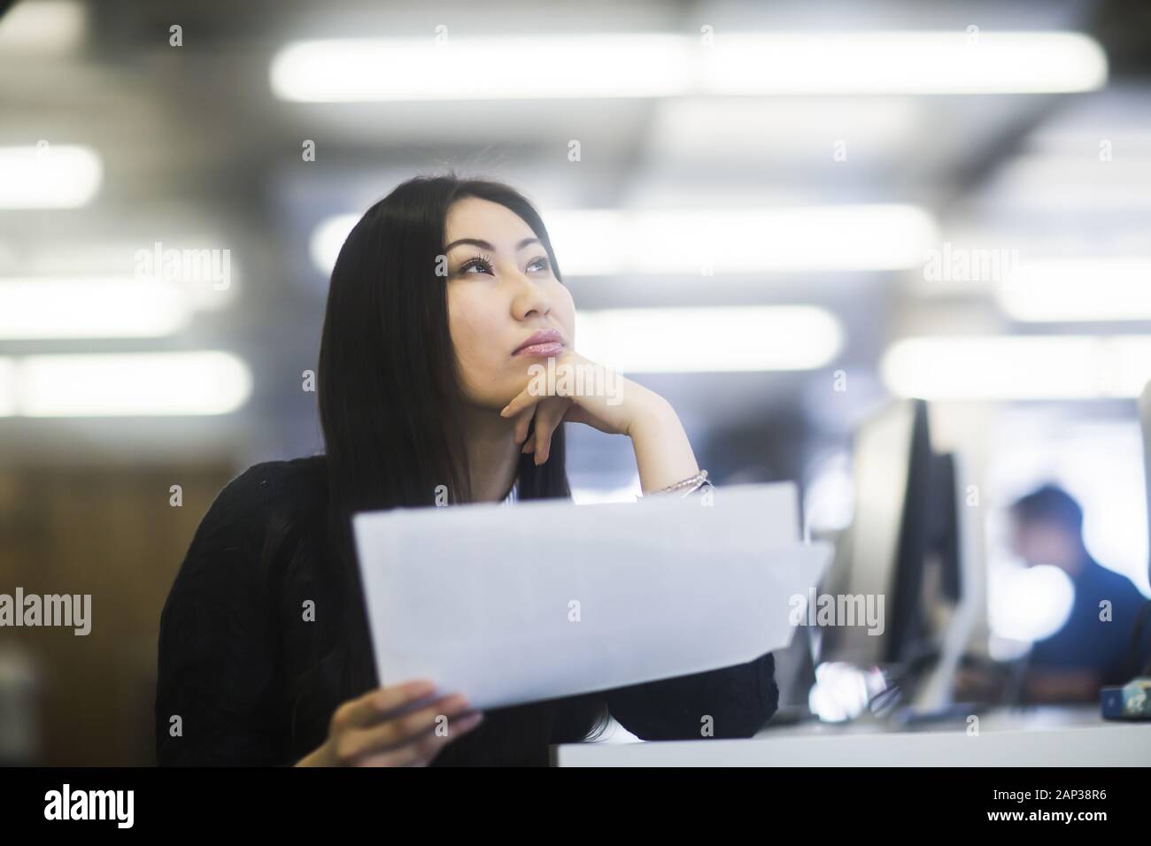 Junge asienfrau mit Papier in einem Büro beobachten Stockfoto