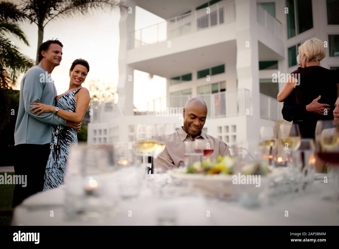 Paar tanzen um ein Mann, der an einem Tisch sitzen. Stockfoto