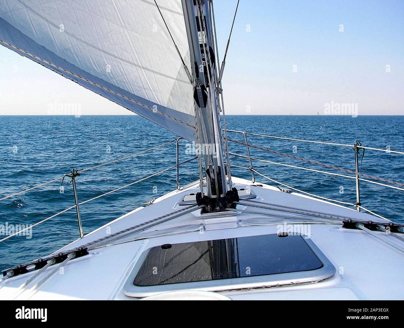 Segelboot deck mit Mast und Segel auf blauem Wasser Stockfoto