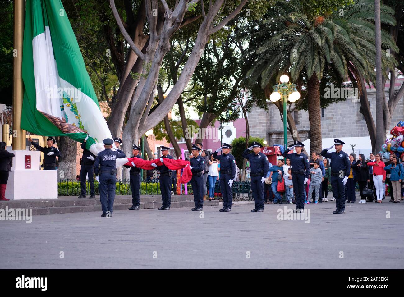 Puebla, Mexiko. Zeremonielle Absenken der Mexikanischen Flagge von der städtischen Polizei in zentralen Platz Stockfoto