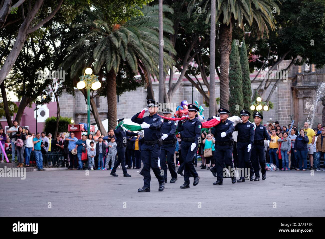 Puebla, Mexiko. Zeremonielle Absenken der Mexikanischen Flagge von der städtischen Polizei in zentralen Platz Stockfoto