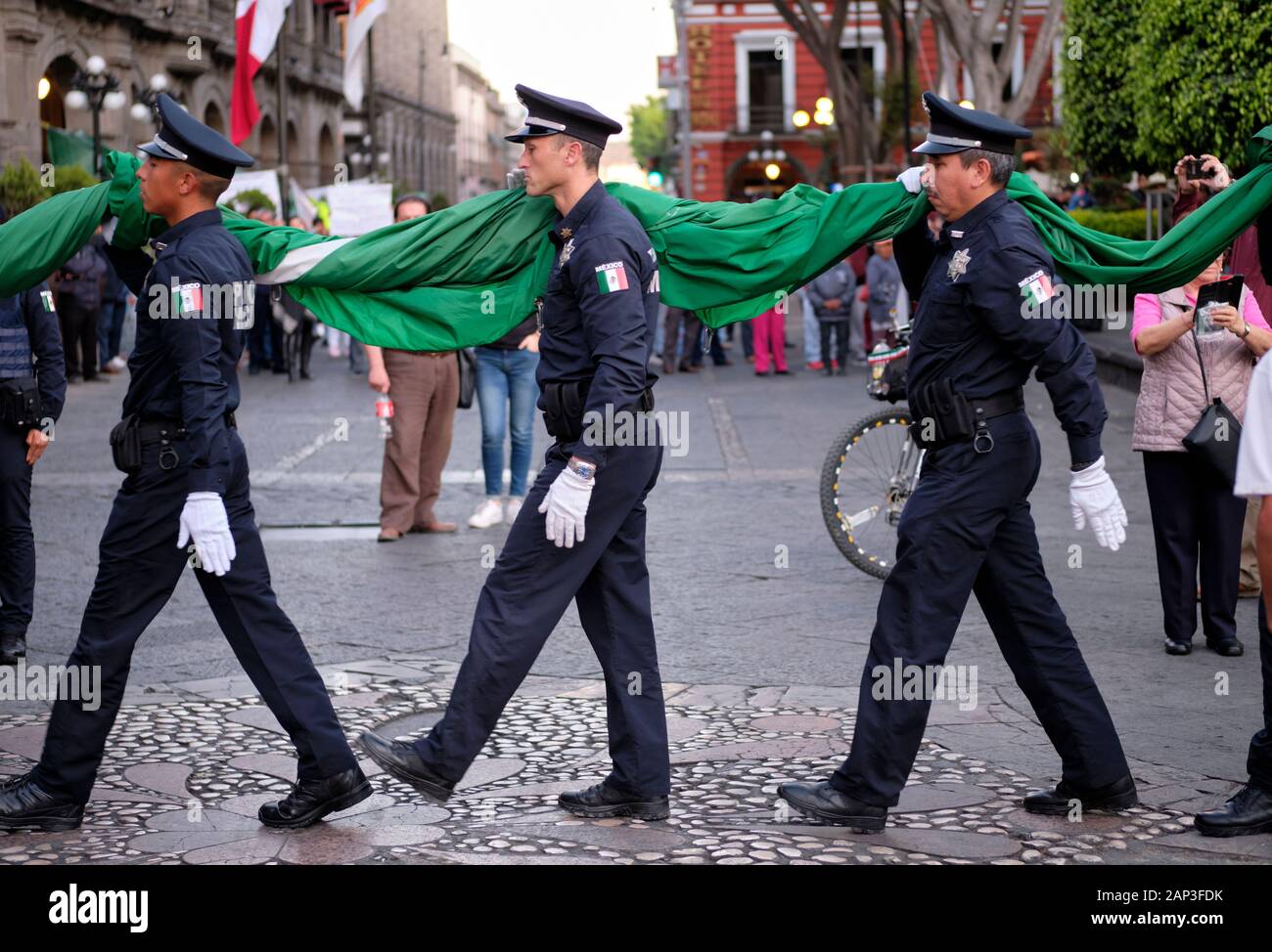 Puebla, Mexiko. Zeremonielle Absenken der Mexikanischen Flagge von der städtischen Polizei in zentralen Platz Stockfoto