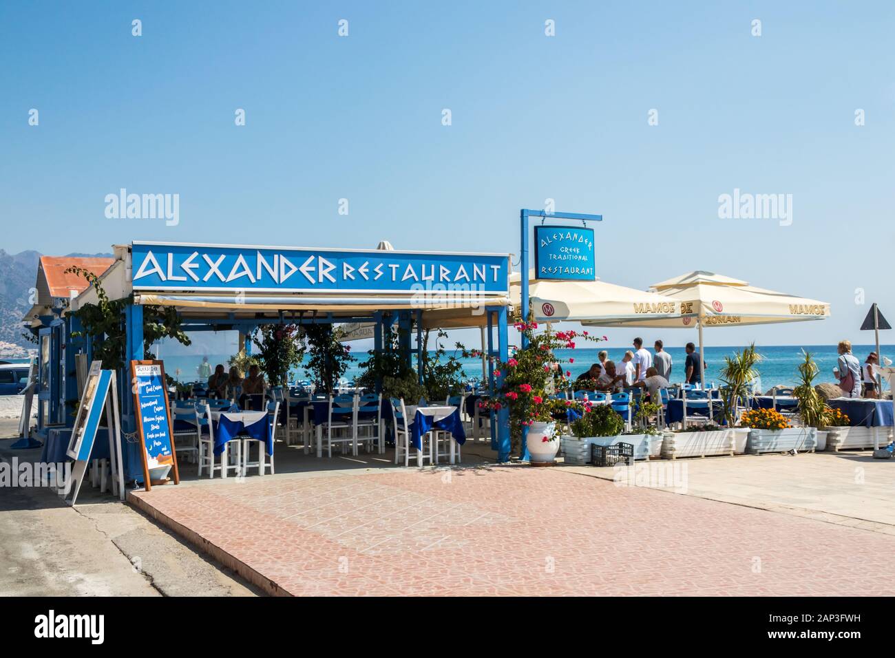 Kardamena an, Kos, Griechenland - 20. September 2019: Menschen zu Fuß entlang der Promenade vorbei an der Restaurant Alexander. Die Stadt ist ein beliebtes Ferien destina Stockfoto