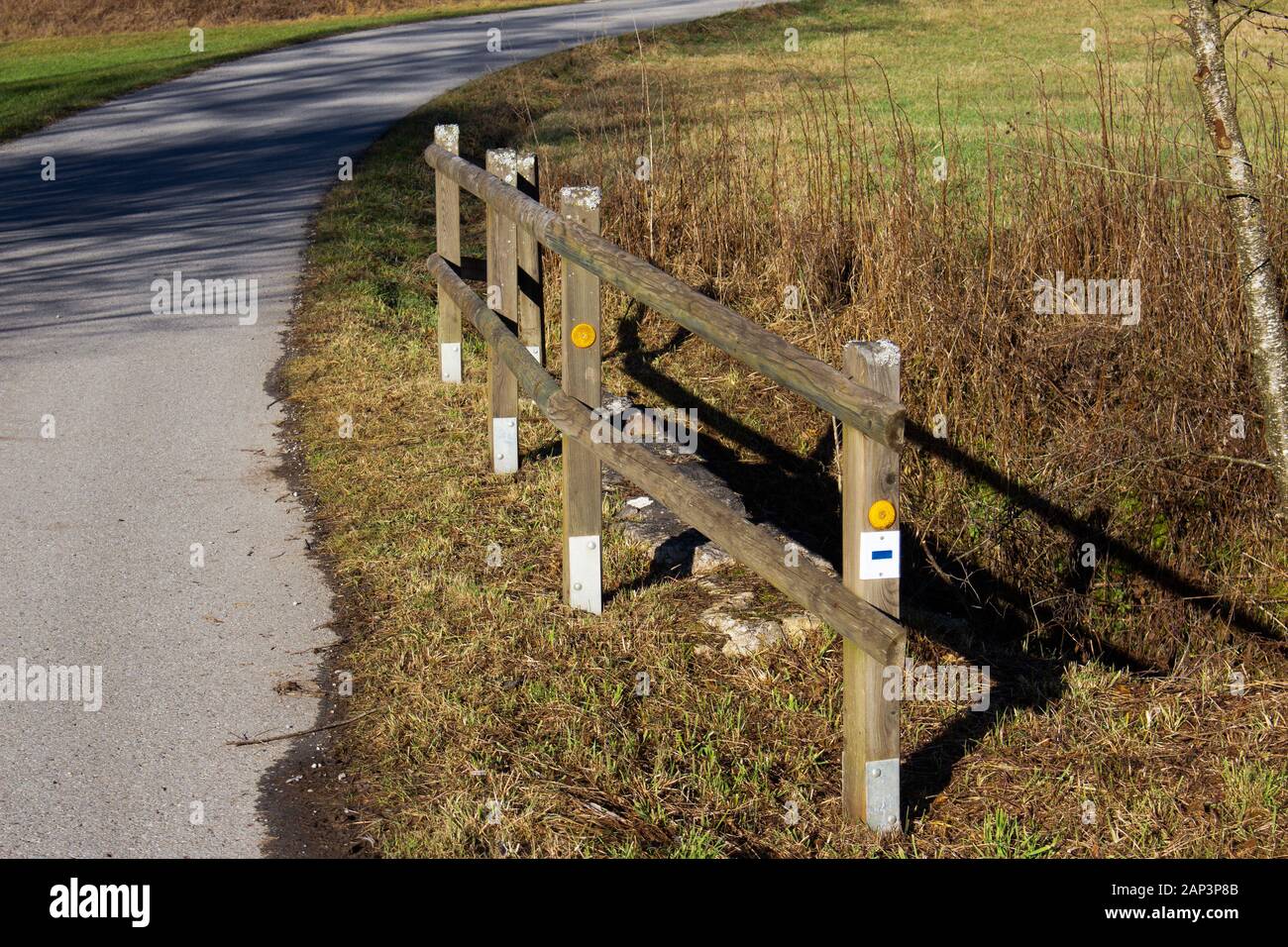 Holzzaun an der Seite eines Landes Straße mit orangefarbene Reflektoren Stockfoto