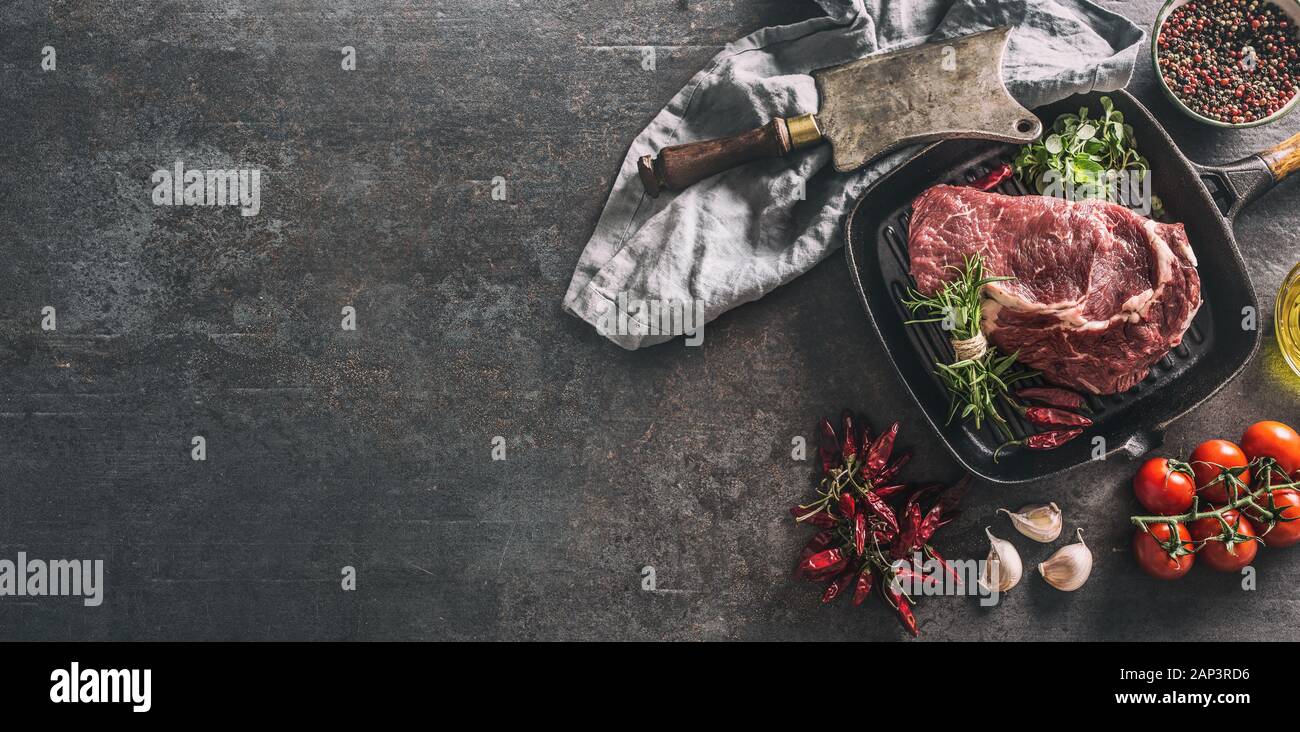 Rindfleisch ribe Eye Steak in der Grillpfanne mit Rosmarin oregano Salz Pfeffer Gewürze Knoblauch und Tomaten Stockfoto