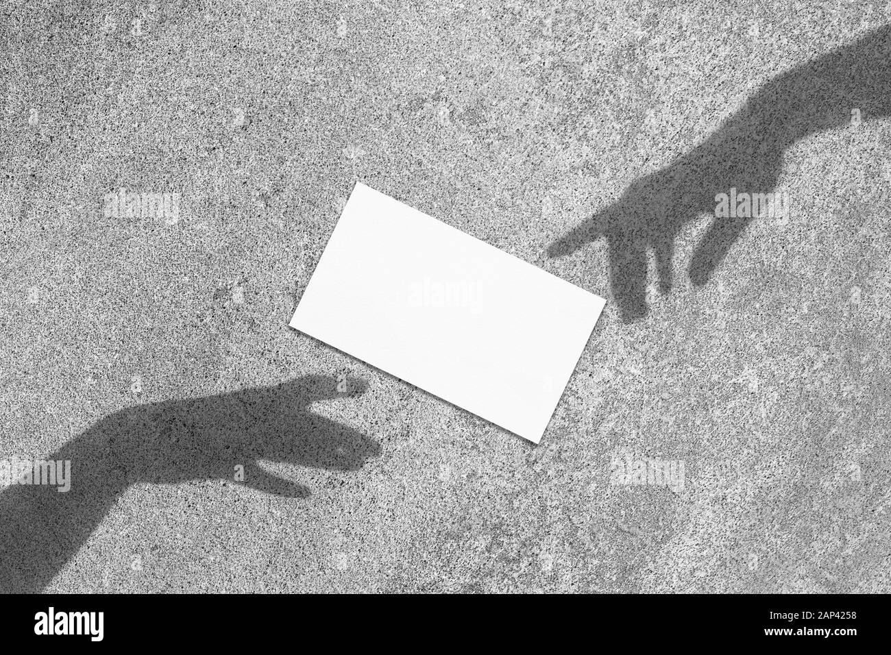 In der Nähe von Leer weißes Rechteck Visitenkarte mockup schräg liegend mit renaissance Händen Schatten auf neutral Hellgrau konkreten Hintergrund. Flach Stockfoto