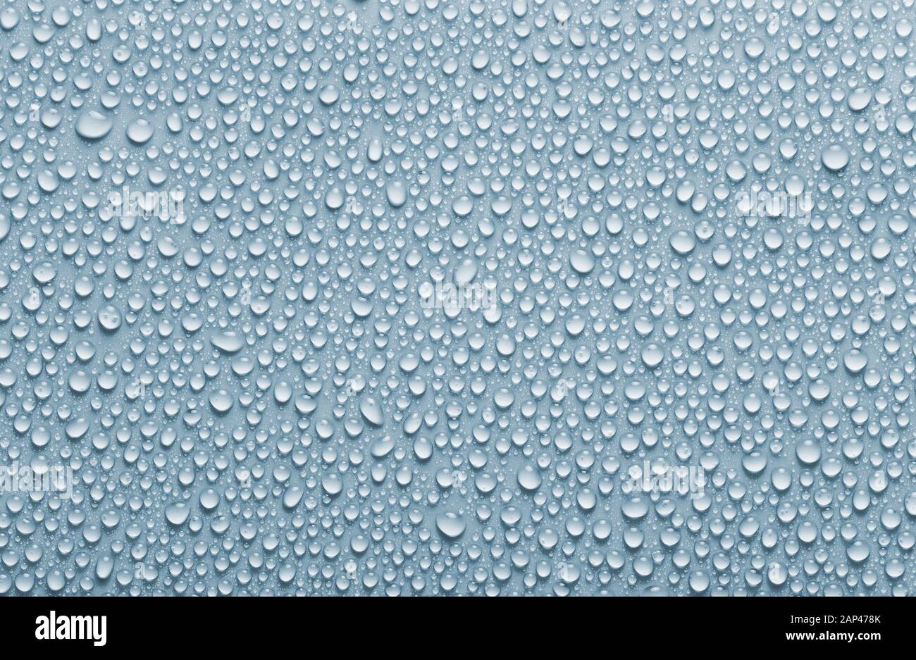 Regen fällt Hintergrund, blau gefärbtes Wasser lässt Textur fallen Stockfoto