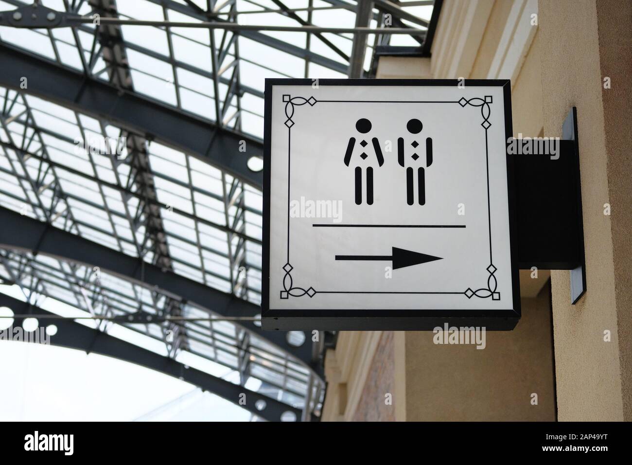 Die in modernem Stil gefertigte Toilette gibt der Toilette im Einkaufszentrum Richtung. Vertikale Ansicht. Stockfoto