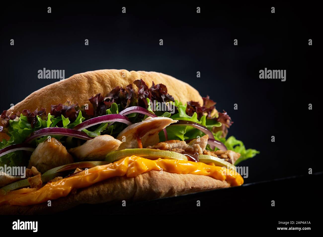 Fladenbrot gefüllt mit Huhn, Salat, Käse Soße und Gemüse auf einem dunklen Hintergrund, selektive konzentrieren. Street Food, Fast Food, dunklen Holzmöbeln backgr Stockfoto