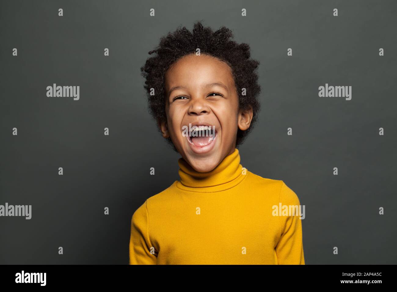 Lachendes Kind auf grauem Hintergrund Stockfoto