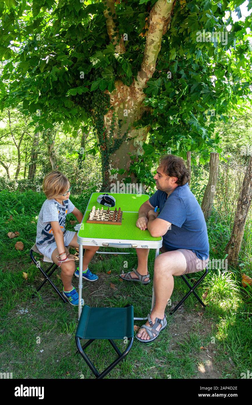 Vater und Sohn spielen Schach im Freien Stockfoto