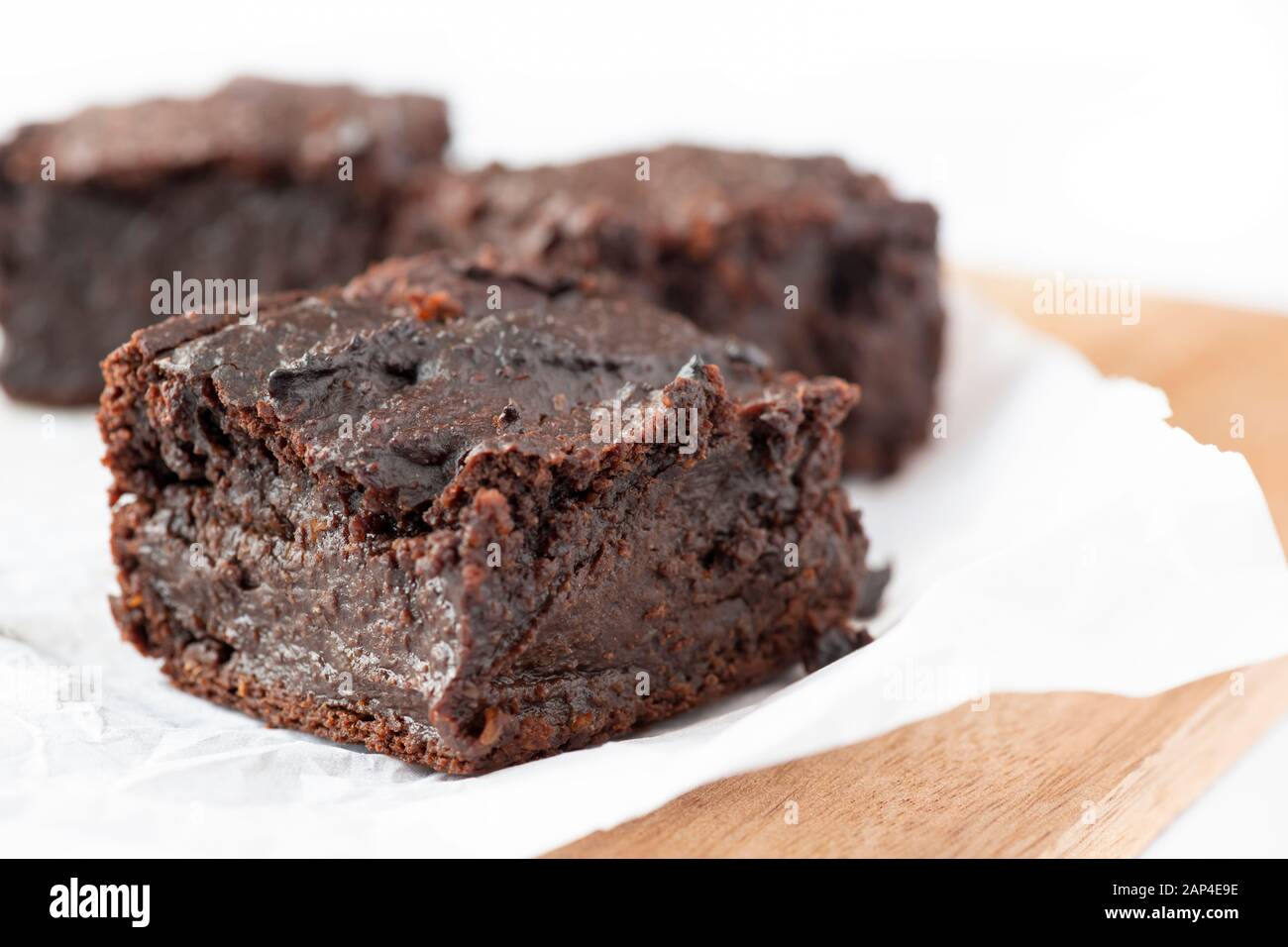 Auf der Basis von veganen Schokoladenbrownies aus Süßkartoffeln auf weißem Hintergrund selektiver Fokus für den Kopierbereich Stockfoto