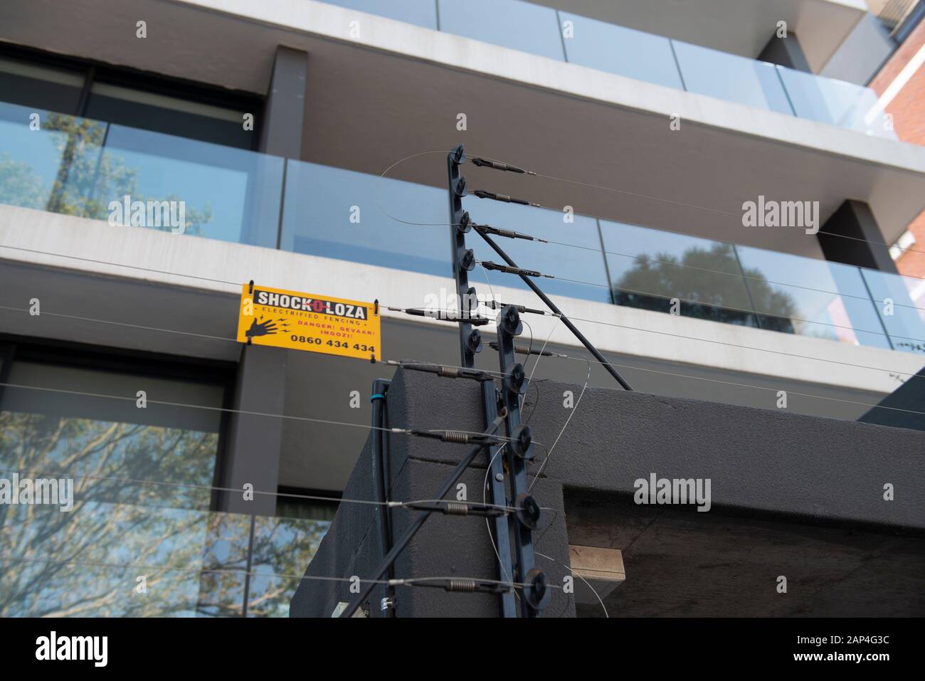 Sicherheit ist ein Anliegen in reicheren Gegenden von Kapstadt mit elektrischen Zäunen und Draht, auch wenn die Dinge einigermaßen sicher sind. Stockfoto