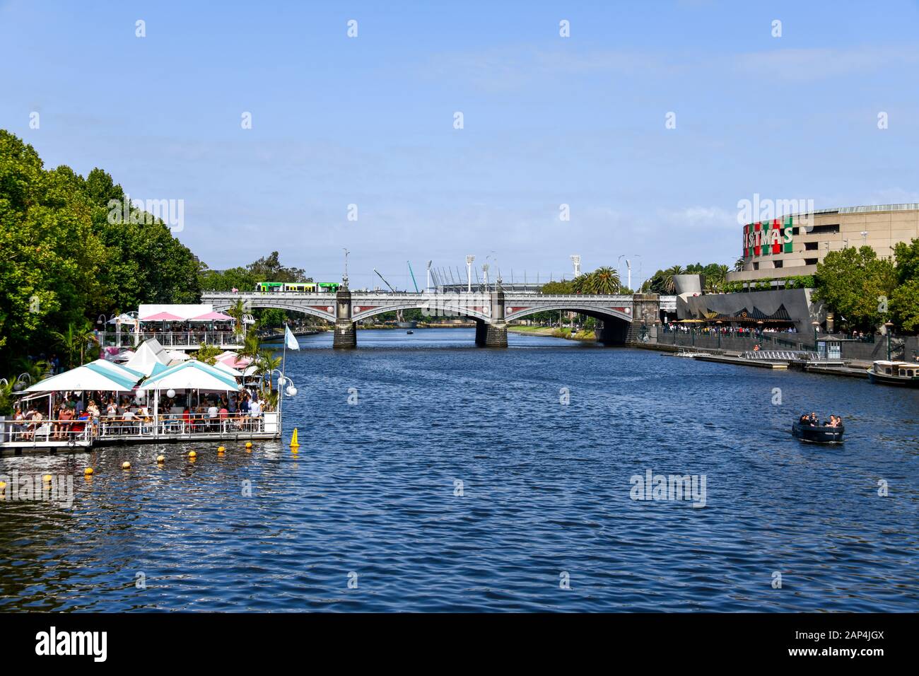 Fauler sonniger Nachmittag auf dem Yarra River, Melbourne, Australien mit schwimmendem Restaurant, Booten, Brücke, Straßenbahn und MGG im Hintergrund Stockfoto