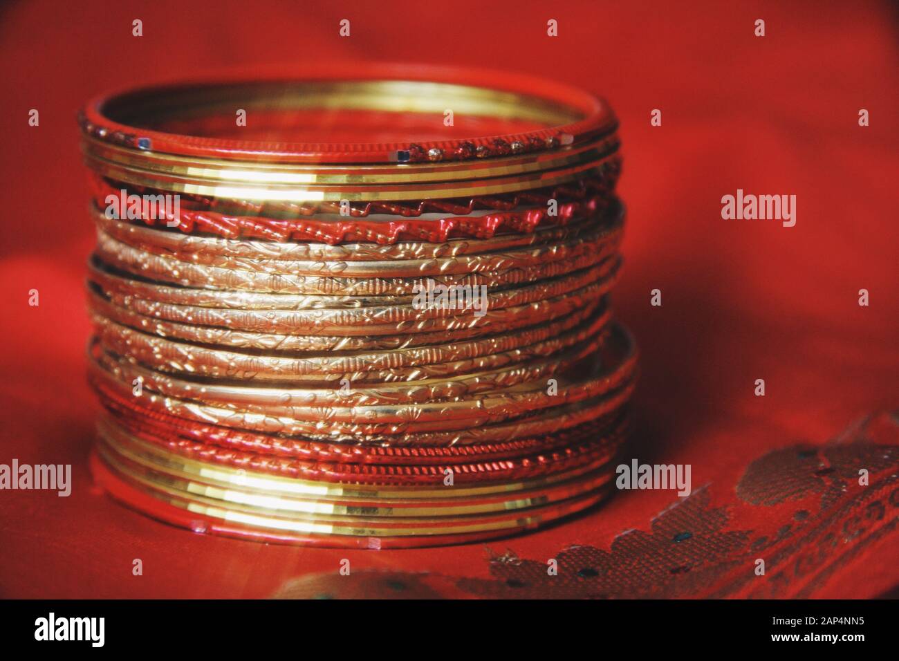 Nahaufnahme von indischen Bangles. Goldene und rote Banderolben. Schmuck aus indischer Tradition. Stockfoto
