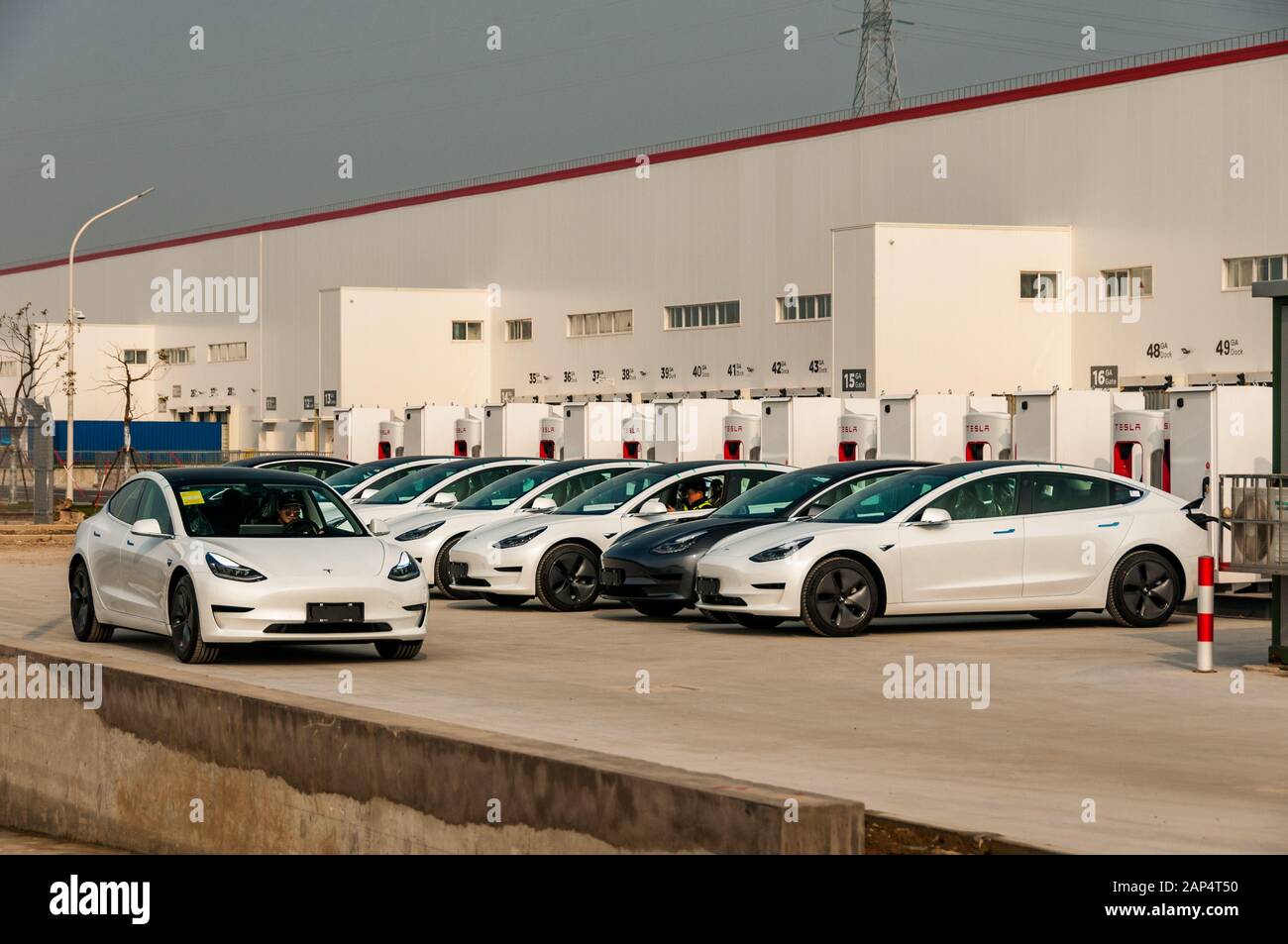 Eine Reihe Chinesen ließen Tesla Model 3s vor der neuen Tesla-Fabrik in Lingang, Shanghai, aufladen. Stockfoto