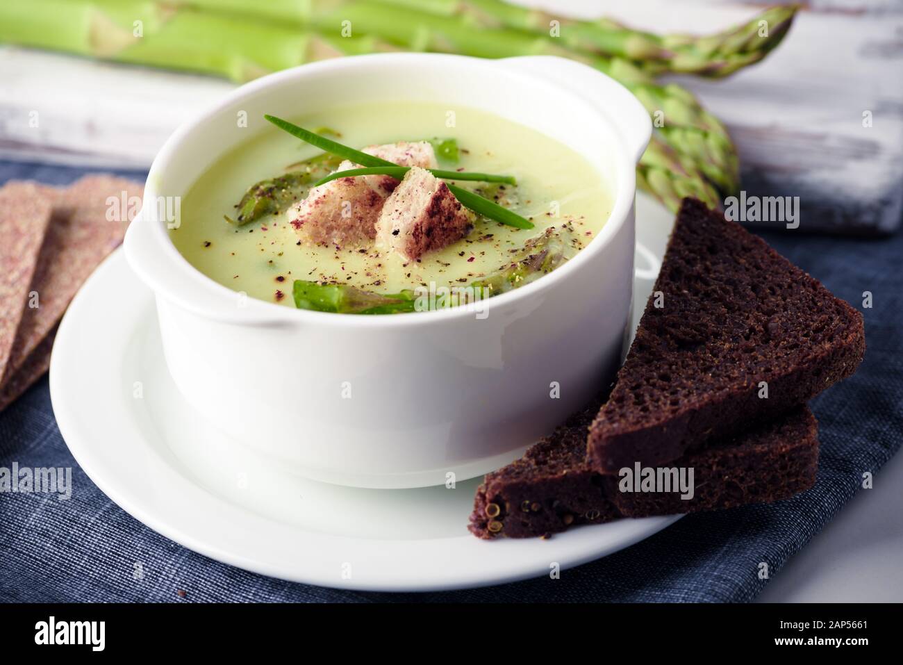 Spargel Suppe mit Schwarzbrot in Weiß Schüssel Nahaufnahme. Essen Fotografie Stockfoto