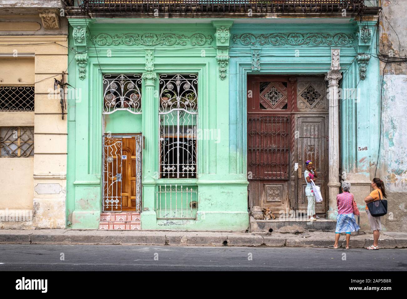Die Menschen sprechen außerhalb der bunten Fassaden von Gebäuden, Havanna, Kuba Stockfoto
